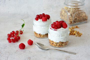 Healthy Yogurt Parfaits with Granola, Berries and Chia Seeds in small jars decorated with berries