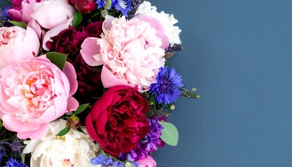 A vibrant bouquet of peonies and wildflowers, showcasing a spectrum of pink, red, and blue hues against a muted backdrop.