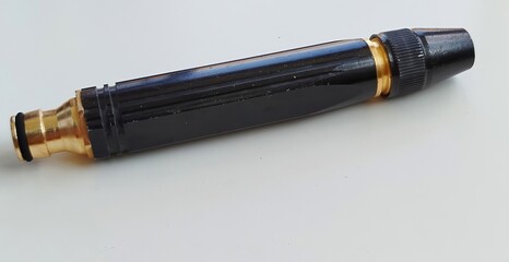 The nozzle features a sturdy metal and plastic construction with a threaded end for hose attachment and a tapered tip for controlling water flow