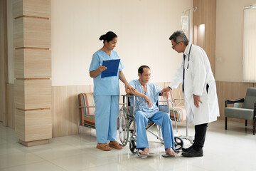 Obraz premium Doctor and nurse take care patient old man with intravenous treatment in wheelchair at hospital 