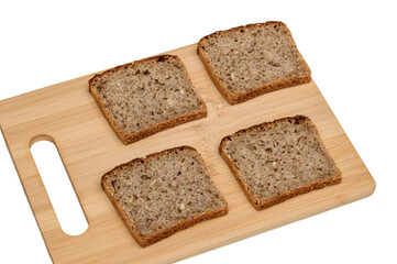 Whole wheat rye bread sliced ​​into thin slices lying on a cutting board. Empty, unspread bread.