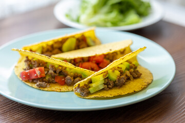 Close-up of Mexican-style tacos with ground meat and vegetables