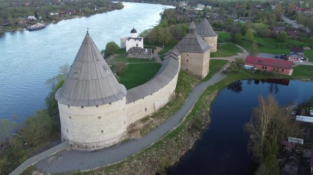Aerial view of the historic Staraya Ladoga Fortress with stone towers along the riverbank