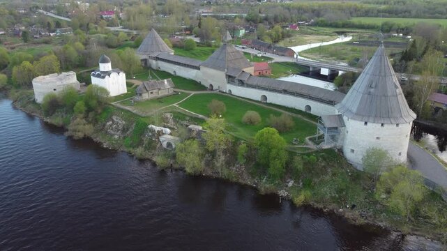 Aerial view of the historic Staraya Ladoga Fortress with stone towers along the riverbank