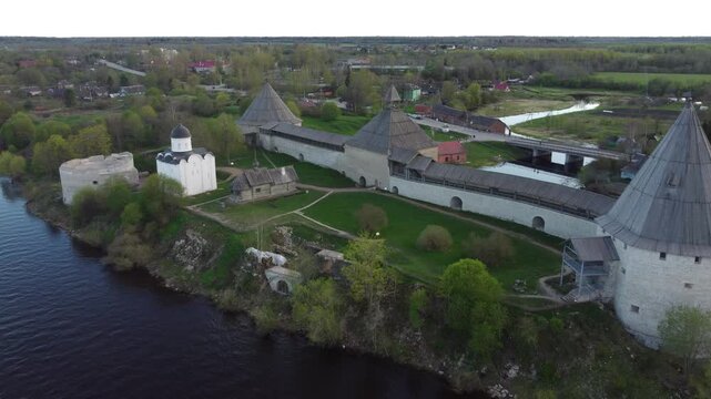Aerial view of the historic Staraya Ladoga Fortress with stone towers along the riverbank