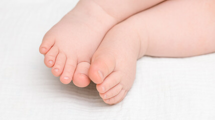 baby's feet on light bed, close-up