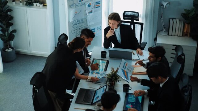 Top view of investor handed financial document to manager while explain marketing idea at meeting table. Diverse people looking at growing graph while listen business team discussion. Directorate.
