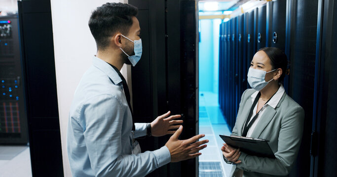 Cybersecurity, discussion and face mask with people in server room for backup, team and technician. Cloud engineer, network hosting and security database with employees for hardware maintenance - Powered by Adobe