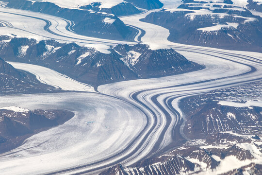 Aerial cockpit view of glaciers and mountains on Greenland coast - Powered by Adobe