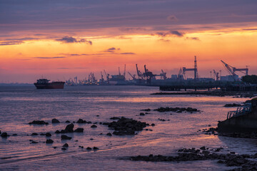 Obraz premium Cargo Ship in the harbour district under Sunset glow