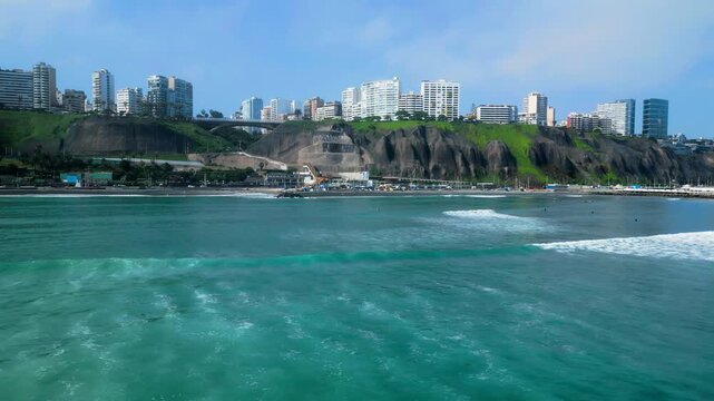 Aerial view of Miraflores coastline with tall buildings rising above rocky green cliffs