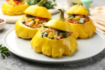Tasty stuffed pattypan squashes on grey textured table, closeup