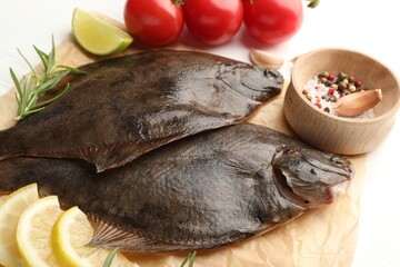 Fresh raw flounder fish and ingredients on white table, above view. Seafood
