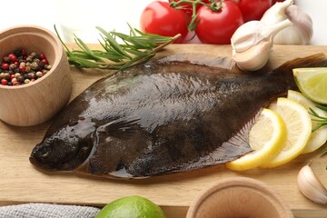 Fresh raw flounder fish and ingredients on white table, above view. Seafood