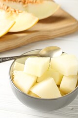 Cut ripe melon on white wooden table, closeup