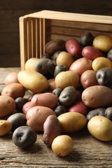 Different types of potatoes on wooden table, closeup