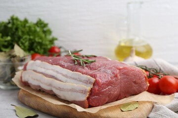 Piece of raw beef meat, tomatoes and spices on grey table, closeup