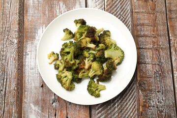 Tasty fried broccoli on wooden table, top view