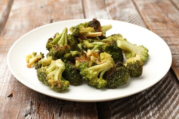 Tasty fried broccoli on wooden table, closeup
