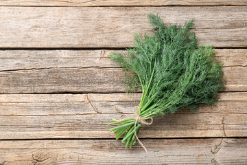 Bunch of fresh dill on wooden table, top view. Space for text