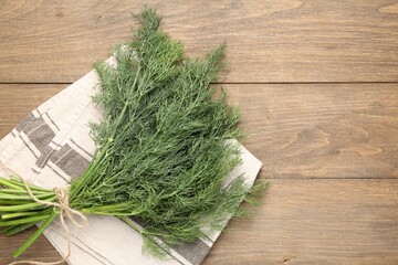 Bunch of fresh dill on wooden table, top view. Space for text