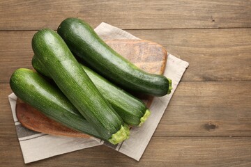 Fresh ripe zucchinis on wooden table, top view. Space for text