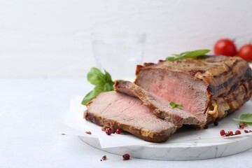 Delicious baked beef meat and spices on light table, closeup. Space for text
