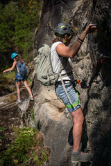 Via Ferrata - Jeune femme pratiquant escalade sur une Via ferrata dans les Alpes Française