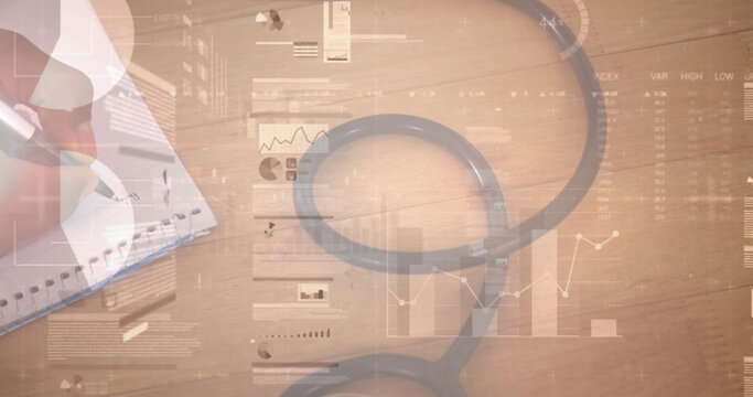 Writing notes by professional in long-sleeve shirt at office desk, with stethoscope and charts