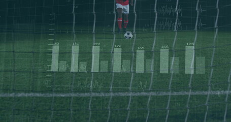 Male soccer player kicking ball toward goal on pitch under floodlights, with analytics overlays