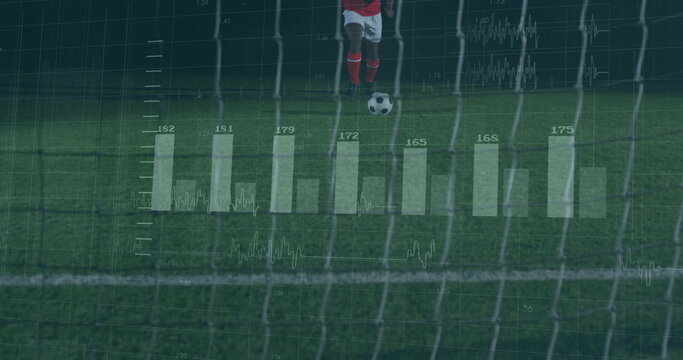 Male soccer player kicking ball toward goal on pitch under floodlights, with analytics overlays - Powered by Adobe