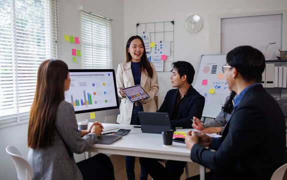 Business asian people, meeting and paper with charts for sales planning, portfolio and company report, digital marketing and team with tech in discussion for brainstorming, idea or plan of growth
