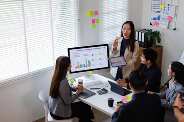 Business asian people, meeting and paper with charts for sales planning, portfolio and company report, digital marketing and team with tech in discussion for brainstorming, idea or plan of growth