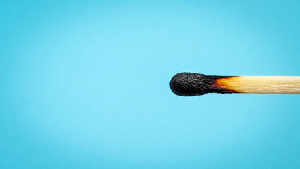  Lone Burnt Matchstick on Pastel Blue Background