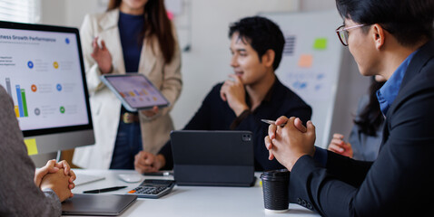Business asian people, meeting and paper with charts for sales planning, portfolio and company report, digital marketing and team with tech in discussion for brainstorming, idea or plan of growth
