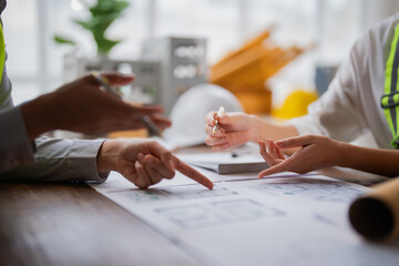 Architects and engineers engaging in a collaborative discussion about blueprints during a meeting,...