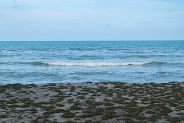 Waves rolling onto a sandy beach under a bright blue sky