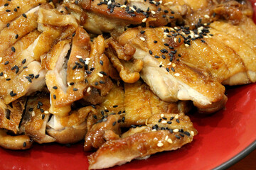 Close-up Japanese teriyaki chicken with sesame seeds on red plate, authentic Asian grilled chicken food photography for menu and restaurant design

Description: