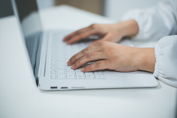 Middle aged female doctor working on laptop in doctor's room