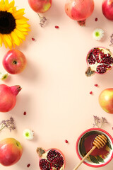 Rosh Hashanah Jewish holiday concept. Flat lay vertical background with apples, honey, pomegranate, sunflower, and flowers