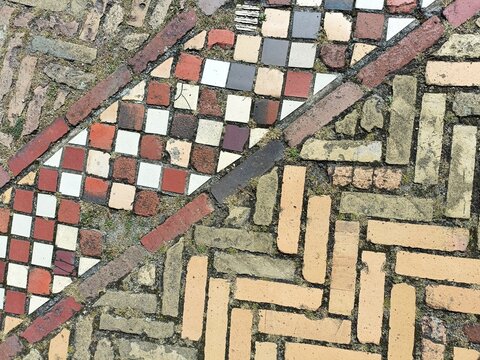 Decorative square and rectangular paving bricks in contrasting colors and lines on a European walkway