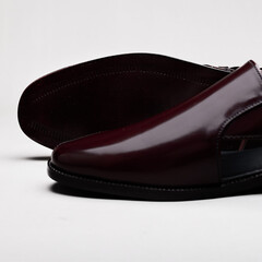 Closeup of a stylish burgundy leather sandal isolated on white background