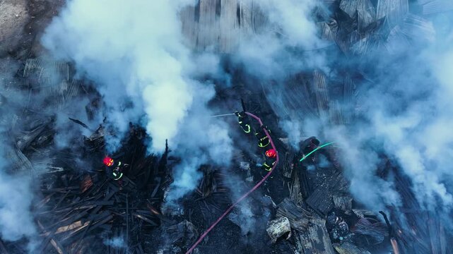 Khagrachari, Bangladesh - 20 August 2025: Aerial view of firefighters bravely battling a blaze, their hoses a stark contrast against the smoke filled backdrop.