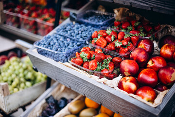 Fresh strawberries, nectarines, and blueberries at an outdoor summer market.