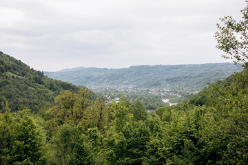 Obraz premium Green spring mountain landscape with a small town nestled in the valley below.