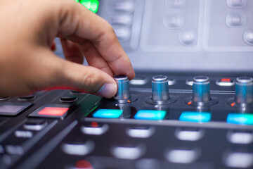 Mixer. Manual volume slider adjustment on a black audio mixer in a dark studio with multiple control knobs and buttons. Concert sound control.