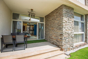 Garden patio terrace of a luxury apartment home in tropical resort with furniture and garden