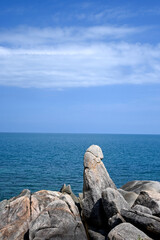 Serene Coastal View with Unique Rock Formation Against the Clear Blue Sea and Sky