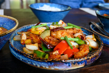 Colorful Asian Stir-Fry with Chicken and Vegetables on Rustic Table Setting in Natural Light