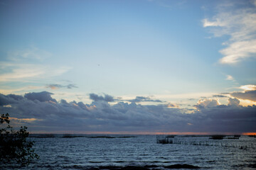 Obraz premium sunset in the sea. Beautiful colorful sky and cloud in twilight time background. Orange fluffy clouds and sun sunlight reflection in the blue sky.